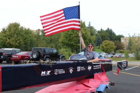 Senior Carver Squiers holds up the American flag at the 2016 Homecoming Parade