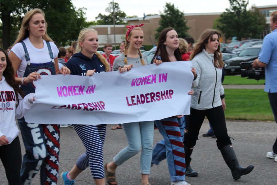 The leadership club walks down the road with their banner