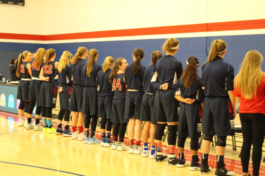 The varsity team lines up for the national anthem 