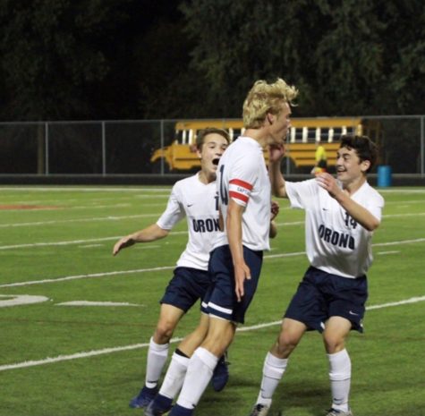 Christian Babo (middle) celebrates goal with teammates Ozzie Ramsey (left) and Jamie Bazil (right).