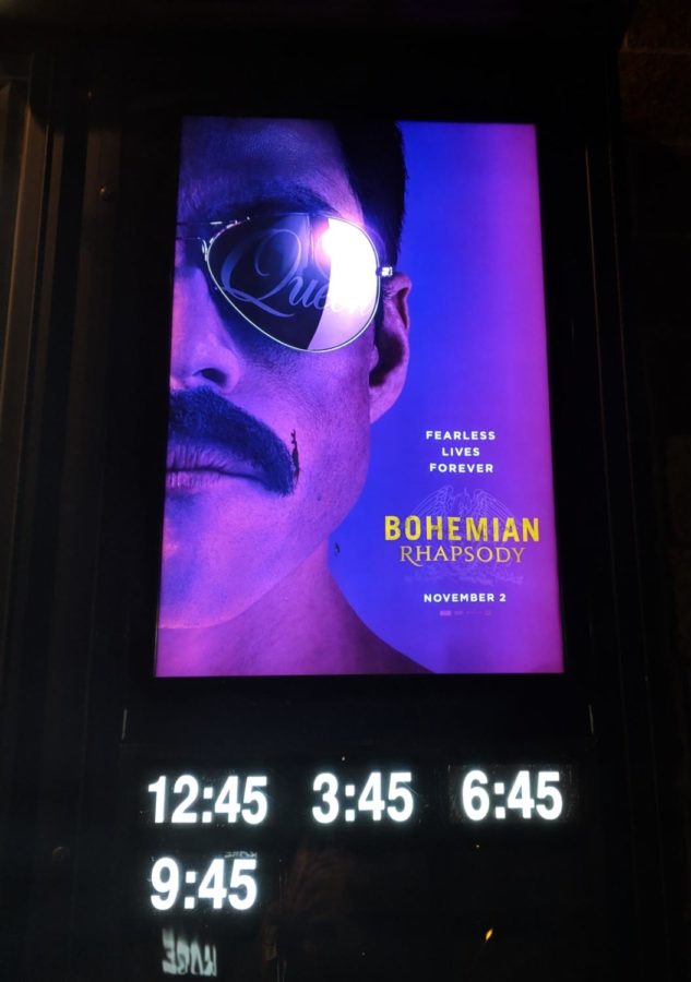 The movie poster that is outside of the theater.