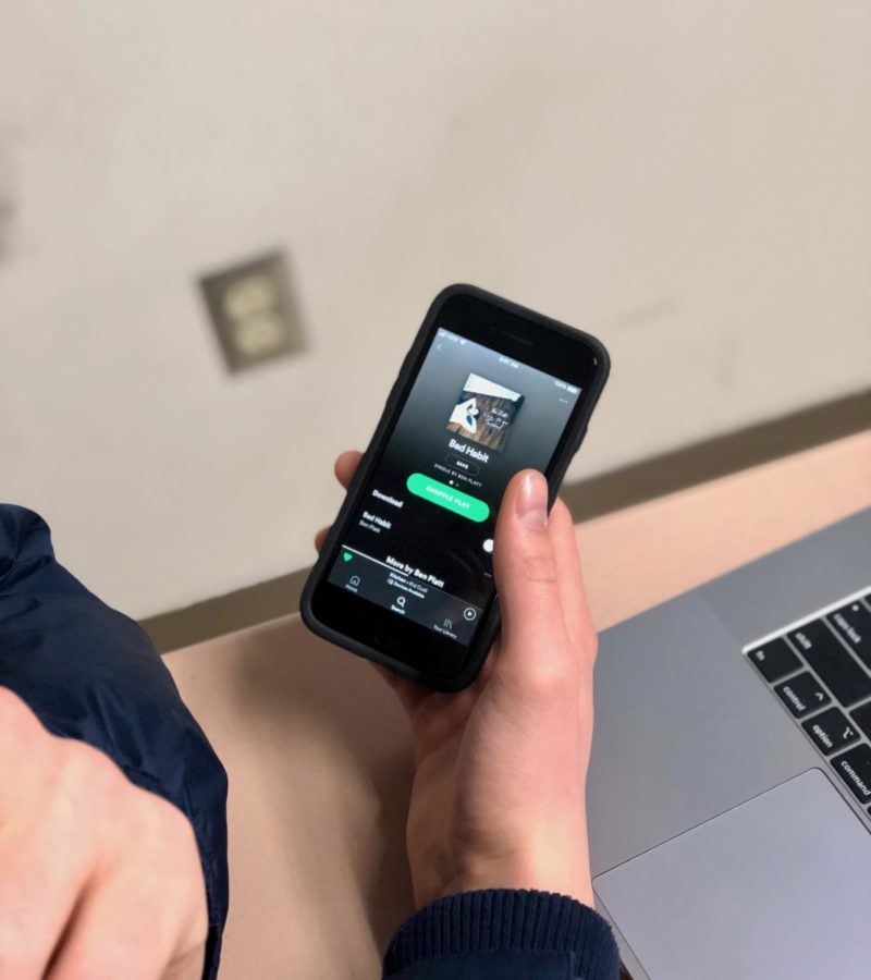 An OHS student listens to “Bad Habit” by Ben Platt on the Spotify app on his phone.