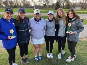 The girls varsity golf team comes together to show off new hardware after a match.