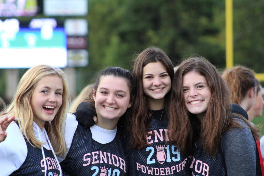 Seniors Darby Sween, Margaret Kraus, Sophie Johnson, and Brooke Parten cheering on the sidelines. 