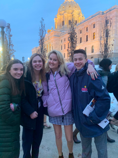 Delegates Emma Davie, Claire Suchy, Nina Johnson, and Blake Ament stand outside the Capitol Building.