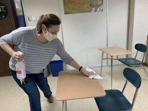 Mrs. Herring sanitizes desks between classes.