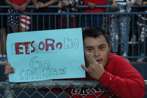 Cheering on his team, senior Andrew Rosales represents Orono with a hand-made sign he made himself.
