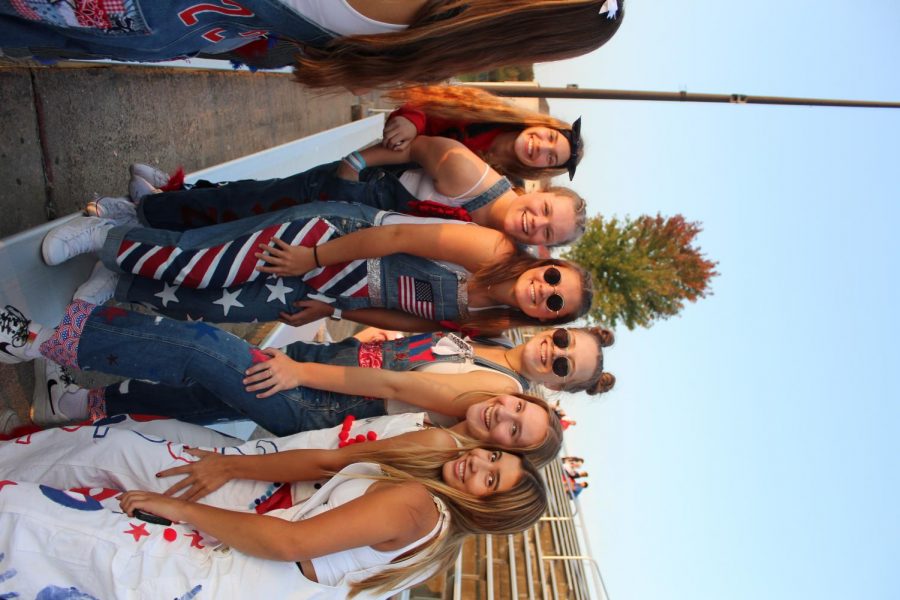 A group of senior girls gather to snap a photo before the Homecoming football game starts.