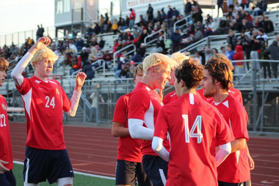The boys varsity soccer team embraces with joy after gaining another splendid goal during their game against Byron.
