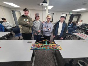 Robotics team members (pictured right to left) John Eberhardt, Adam Haislet, Hudson Reed, and Alex Peterson pose in front of their newly completed bridge after a practice competition. 