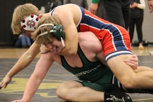 Daniel Bremer takes his opponent to the mat displaying impressive strength in the moment.