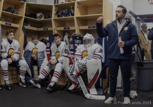 Head Coach Hall gives instructions to his team before their first game for the season.