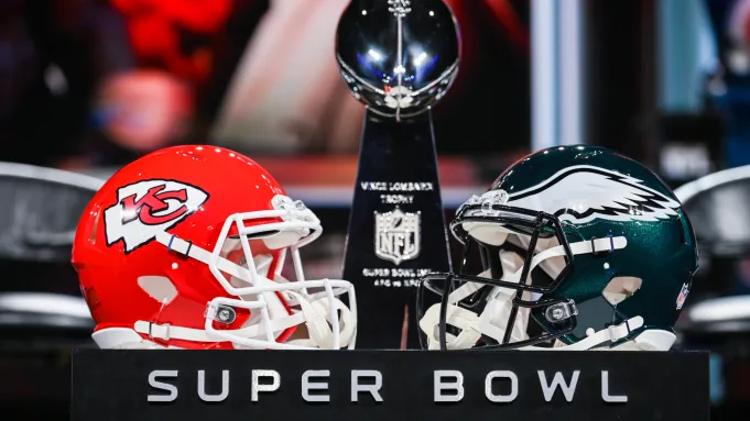 The Vince Lombardi trophy and the helmets Chiefs' and Eagles' helmets