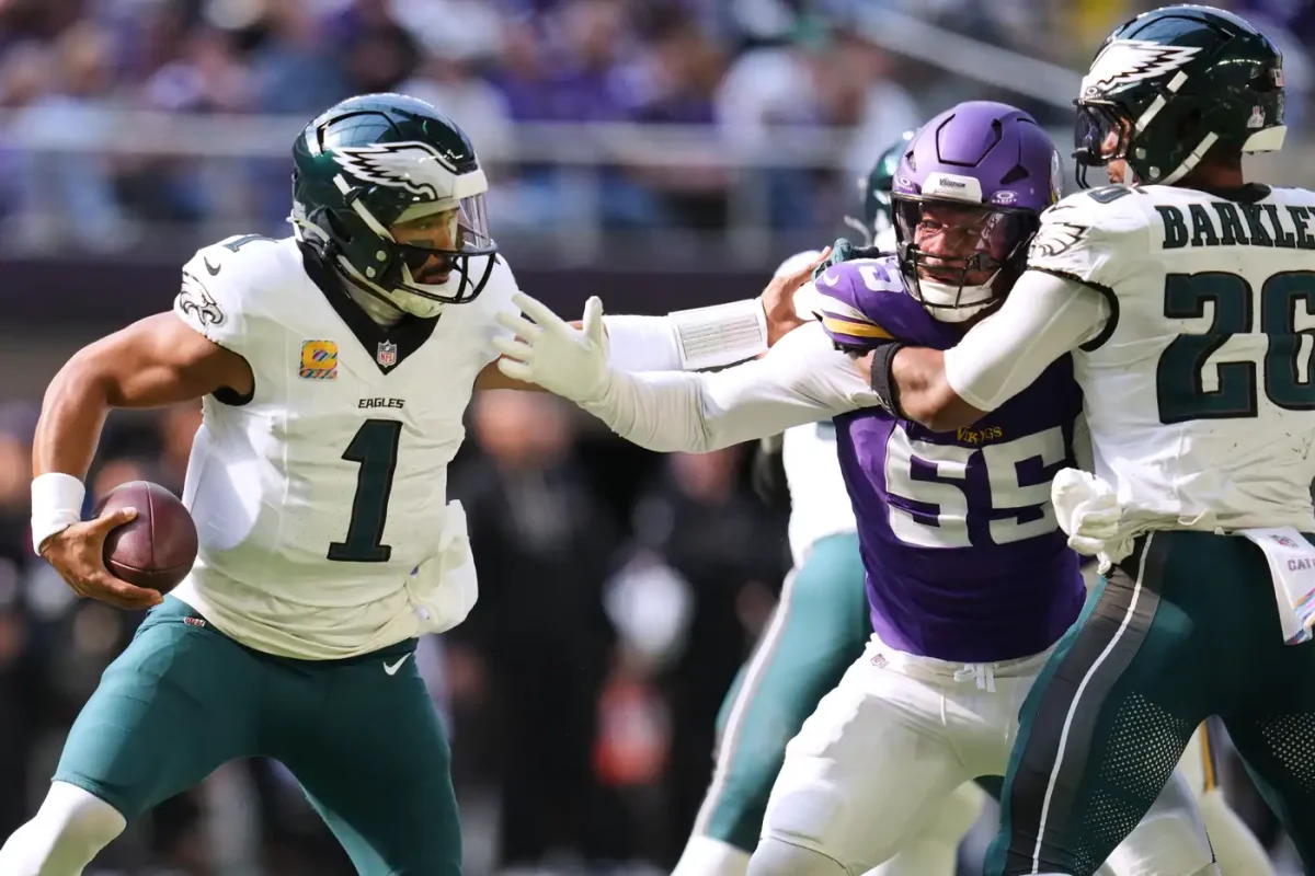 Philadelphia Eagles quarterback Jalen Hurts (1) tries to avoid a tackle from Minnesota Vikings linebacker Eric Wilson (55) during the first half Sunday in Minneapolis.