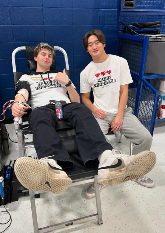 Last year's seniors Henry Jackson and Kai Reidy give blood during last year's fall blood drive.
